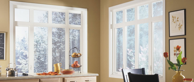 Kitchen with large white casement windows looking out on a snowy yard