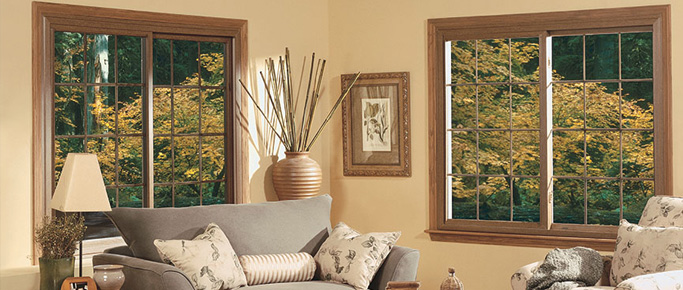 Living room with two wide wood-tone sliding windows overlooking autumn trees
